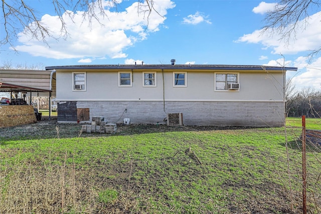 back of house with cooling unit, a carport, and a yard