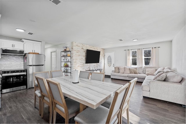 dining area with dark wood-style floors and visible vents