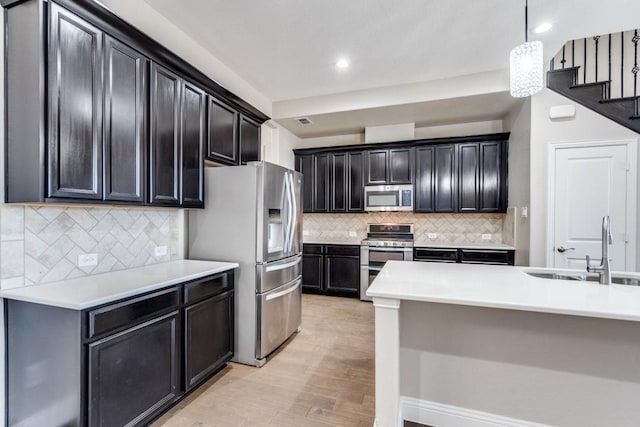 kitchen with appliances with stainless steel finishes, light countertops, and a sink