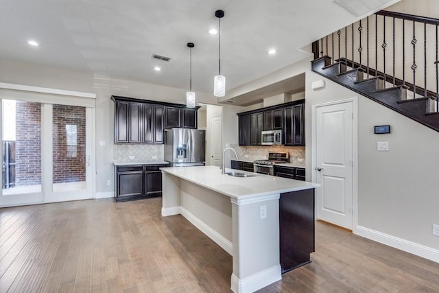 kitchen featuring light wood-style flooring, a sink, visible vents, light countertops, and appliances with stainless steel finishes