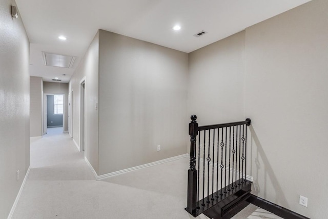 hall featuring carpet, attic access, visible vents, and an upstairs landing