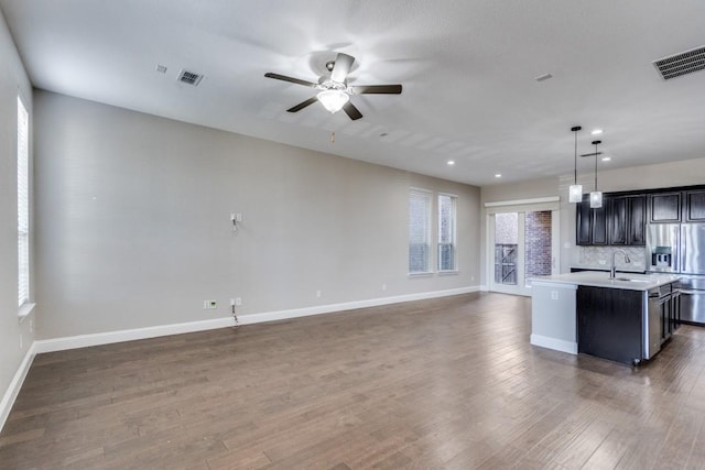 kitchen featuring stainless steel fridge, visible vents, open floor plan, and light countertops