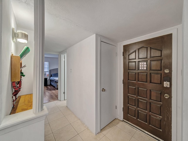 entryway featuring a textured ceiling and light tile patterned flooring