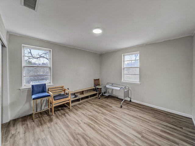 living area featuring wood finished floors, visible vents, and baseboards