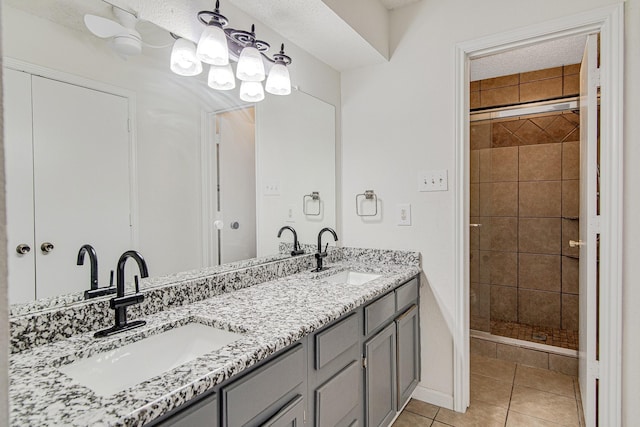 full bath with a sink, double vanity, a stall shower, and tile patterned floors