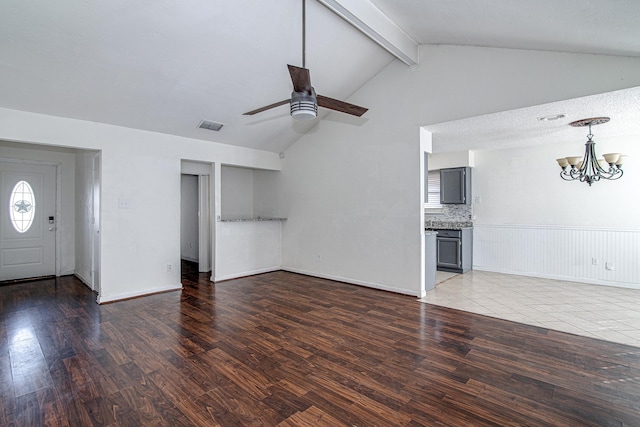 unfurnished living room featuring visible vents, ceiling fan with notable chandelier, vaulted ceiling with beams, and wood finished floors