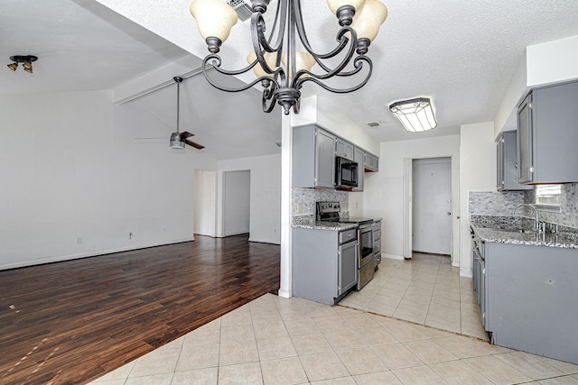 kitchen featuring electric range, light tile patterned floors, gray cabinets, and black microwave