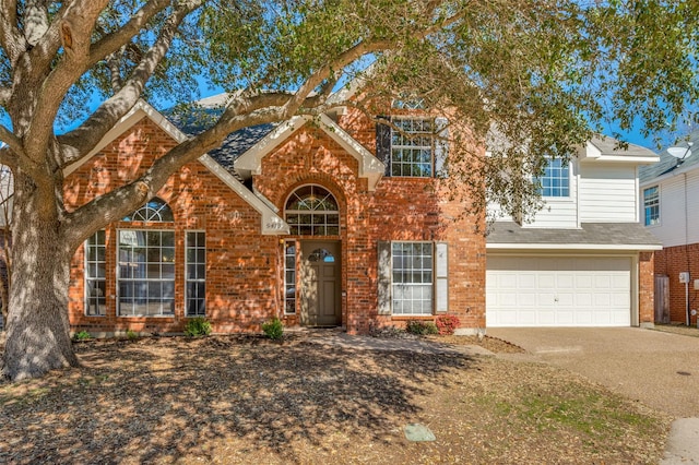 view of front of home featuring a garage, concrete driveway, and brick siding