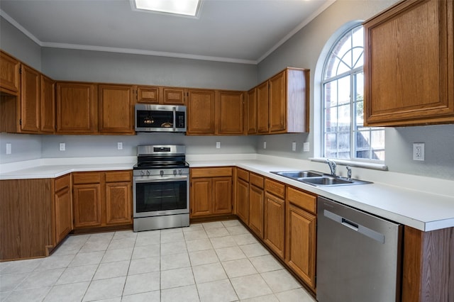 kitchen featuring crown molding, stainless steel appliances, a sink, and brown cabinets