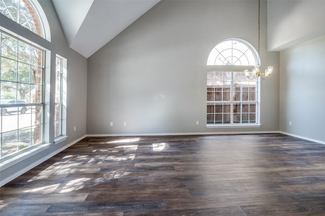 empty room with a healthy amount of sunlight, an inviting chandelier, high vaulted ceiling, and wood finished floors