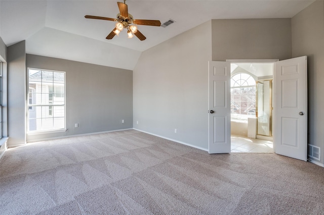 carpeted spare room featuring vaulted ceiling, ceiling fan, visible vents, and baseboards