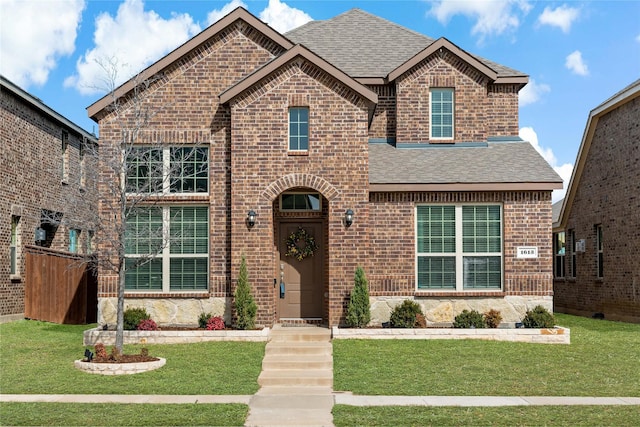 view of front of home with a shingled roof and brick siding