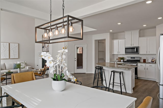 dining area with baseboards, dark wood-style flooring, and recessed lighting