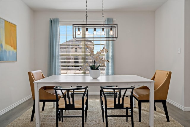 dining space featuring baseboards and wood finished floors