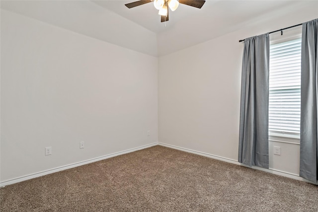 spare room with ceiling fan, carpet, and baseboards