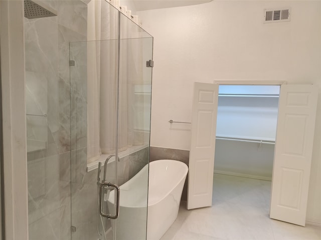 full bath with a spacious closet, a soaking tub, a shower stall, and visible vents