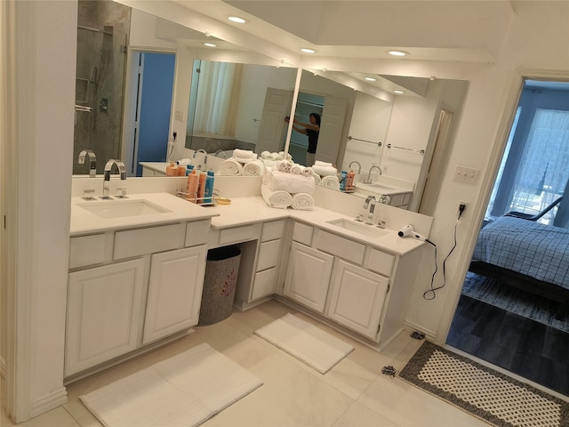 bathroom with ensuite bathroom, double vanity, and a sink