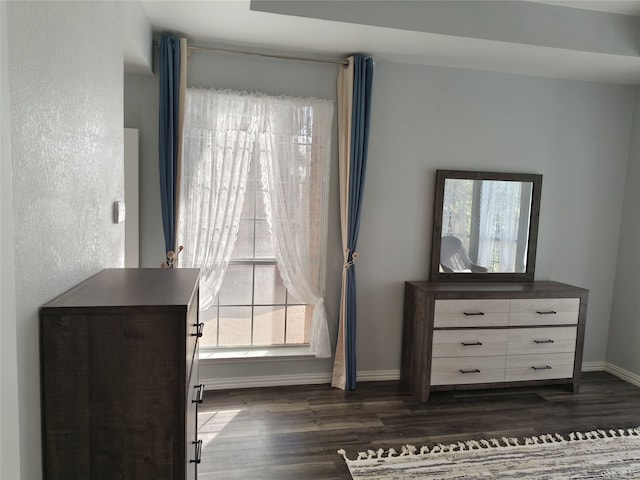 interior space with dark wood-type flooring and baseboards