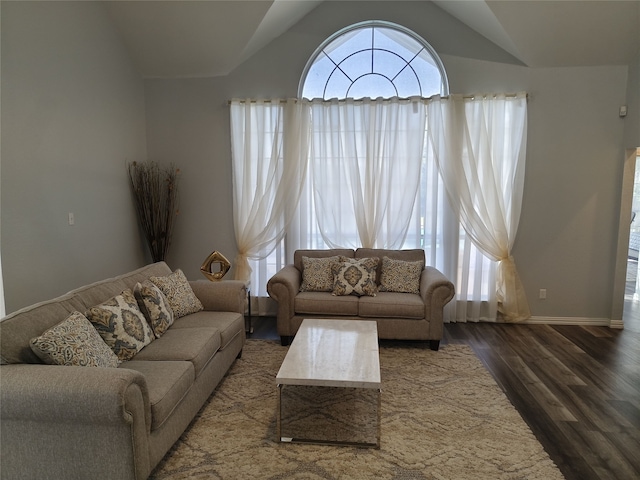 living room with vaulted ceiling, wood finished floors, and baseboards