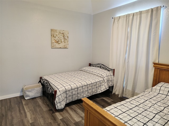 bedroom with dark wood-style flooring and baseboards