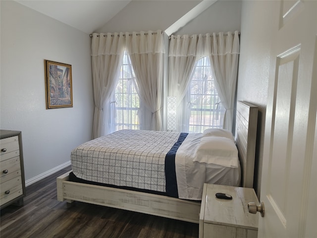 bedroom featuring vaulted ceiling, multiple windows, dark wood-style floors, and baseboards