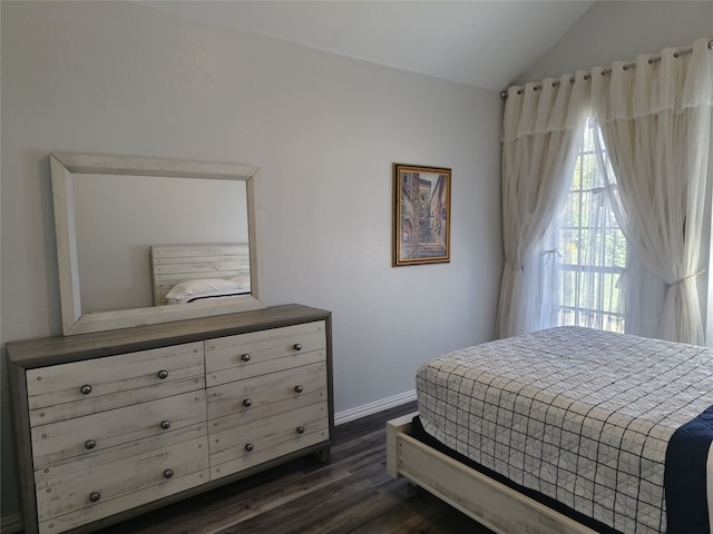 bedroom featuring dark wood-style floors, lofted ceiling, and baseboards