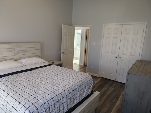 bedroom with dark wood-style floors, a closet, and baseboards