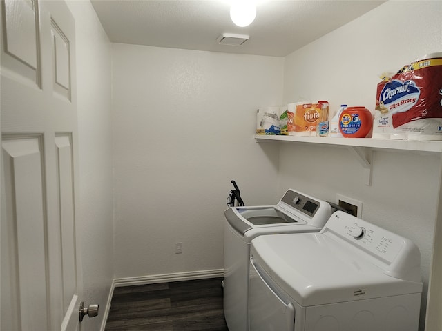 clothes washing area with washer and dryer, laundry area, baseboards, and wood finished floors