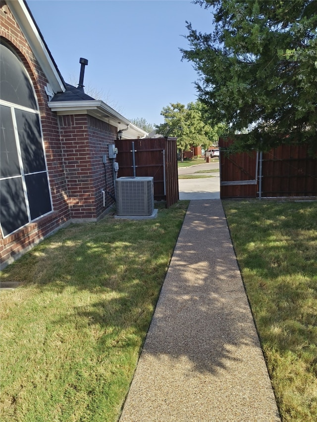 view of yard featuring central AC unit and fence