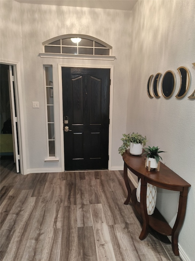 foyer featuring baseboards and wood finished floors