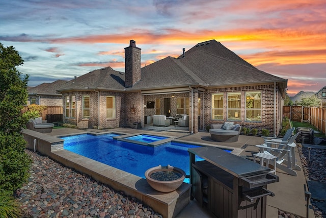 view of pool with a patio area, outdoor lounge area, a pool with connected hot tub, and a fenced backyard