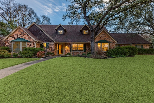 view of front facade featuring brick siding and a front lawn