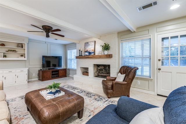 living room featuring a fireplace, visible vents, a wealth of natural light, and beamed ceiling