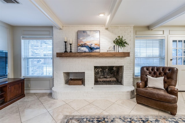 living area with a brick fireplace, crown molding, light tile patterned floors, and beamed ceiling