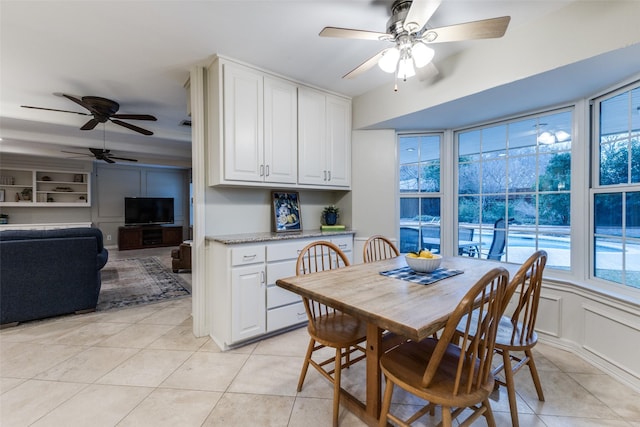 dining space with light tile patterned flooring and a decorative wall