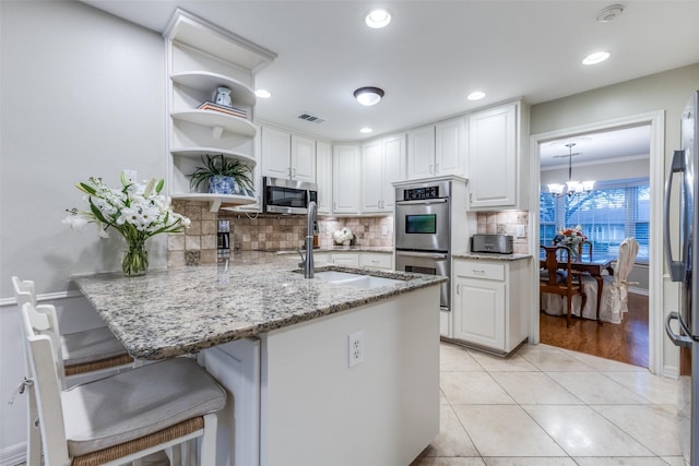 kitchen featuring light stone countertops, appliances with stainless steel finishes, and white cabinets