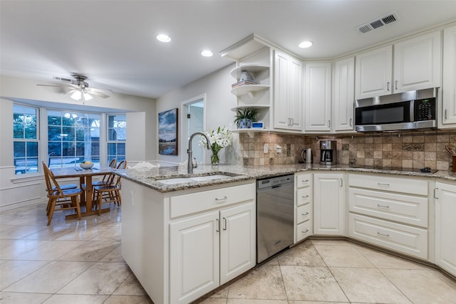 kitchen with stainless steel appliances, a sink, visible vents, white cabinets, and open shelves