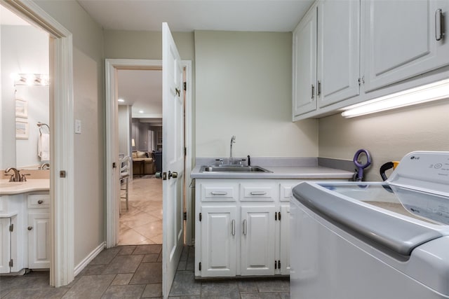 laundry room featuring washer / dryer, cabinet space, and a sink