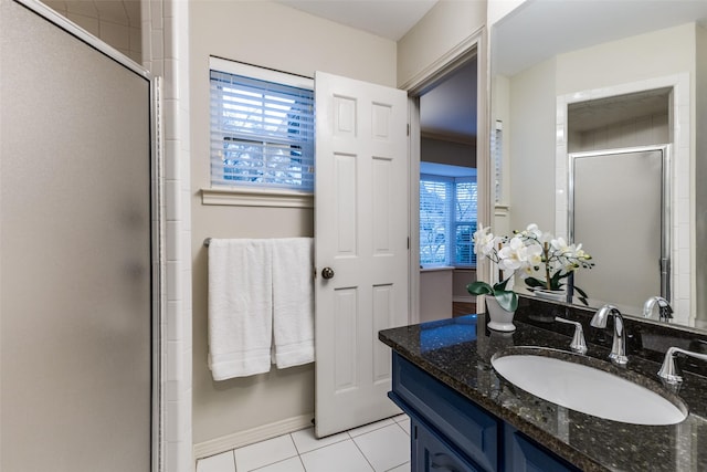 bathroom with a stall shower, tile patterned flooring, baseboards, and vanity