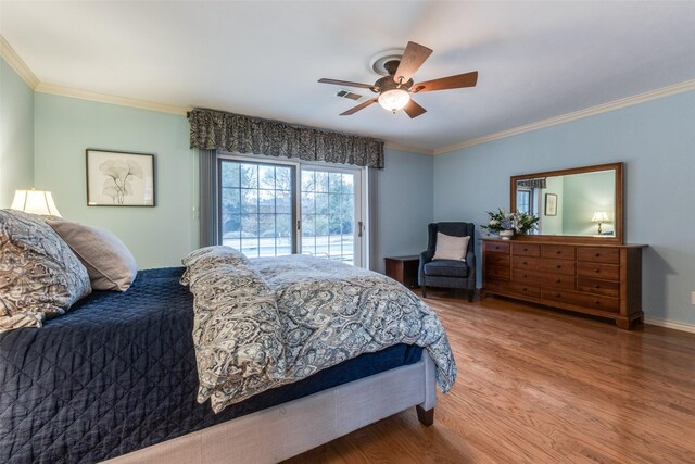 bedroom featuring ceiling fan, wood finished floors, visible vents, and crown molding