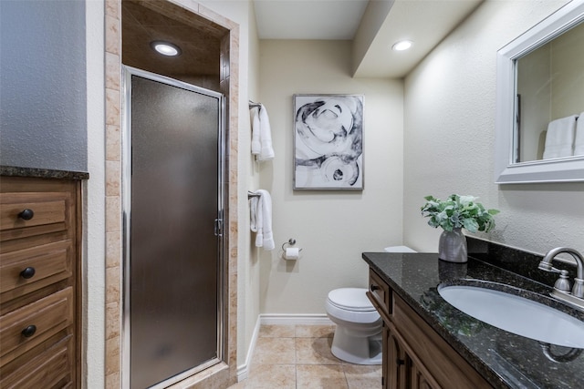 full bathroom with toilet, vanity, baseboards, tile patterned floors, and a stall shower