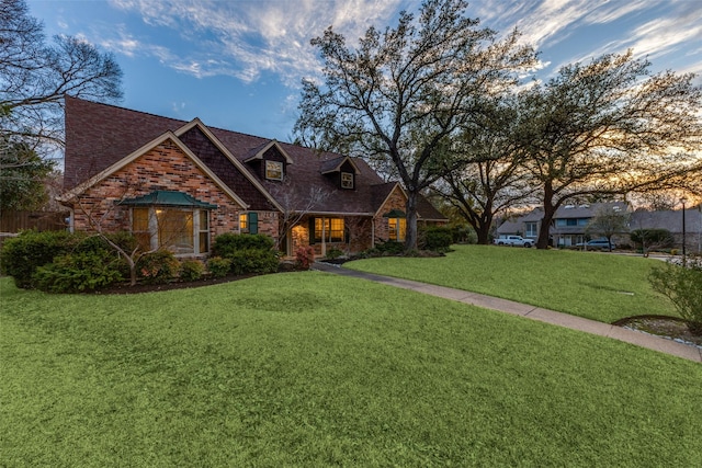 view of front of home with brick siding and a front lawn