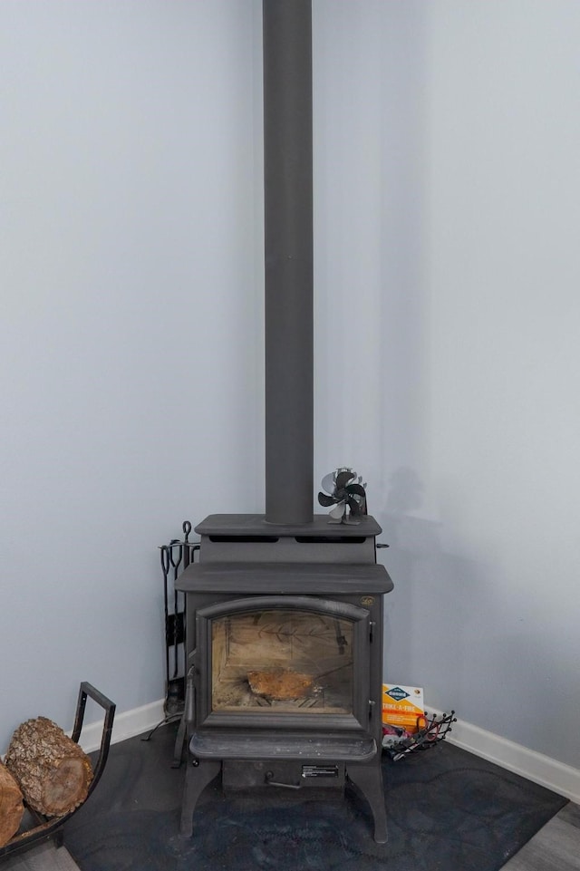 interior details featuring a wood stove and baseboards