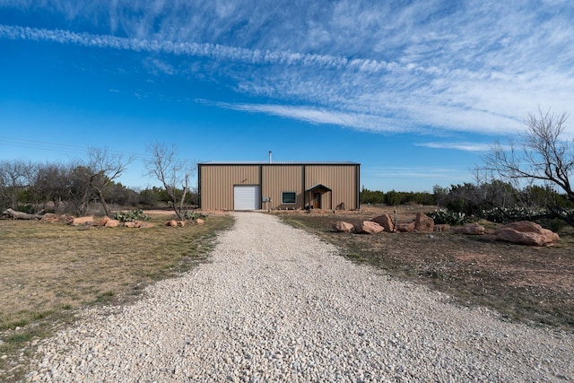 exterior space with a garage, gravel driveway, and an outdoor structure