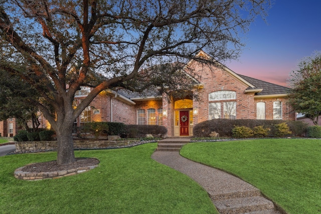 view of front of property featuring brick siding and a front lawn