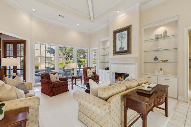 living room with built in features, a fireplace, and ornamental molding