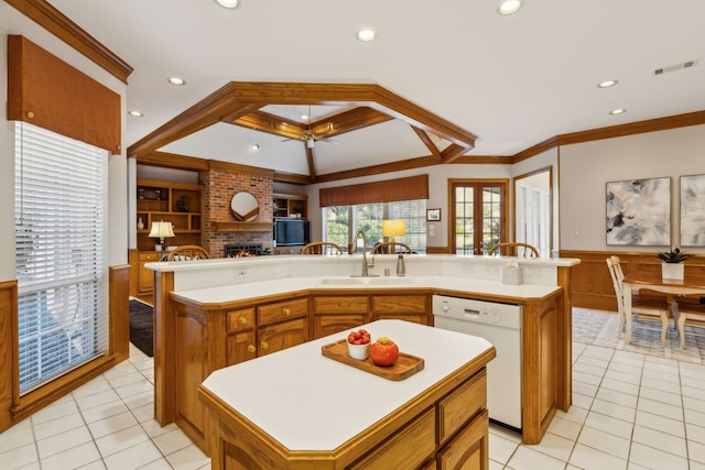 kitchen with a sink, dishwasher, visible vents, and an island with sink