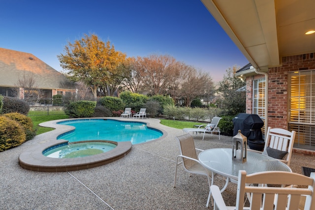 view of swimming pool with a patio, a grill, fence, a pool with connected hot tub, and outdoor dining space