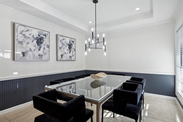 dining room with a tray ceiling, wainscoting, and crown molding