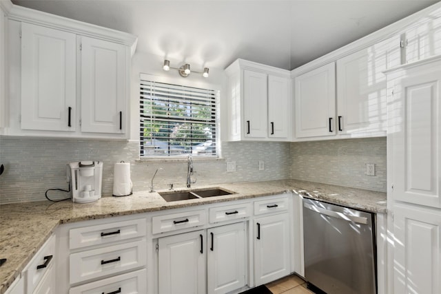 kitchen with tasteful backsplash, white cabinets, a sink, and stainless steel dishwasher